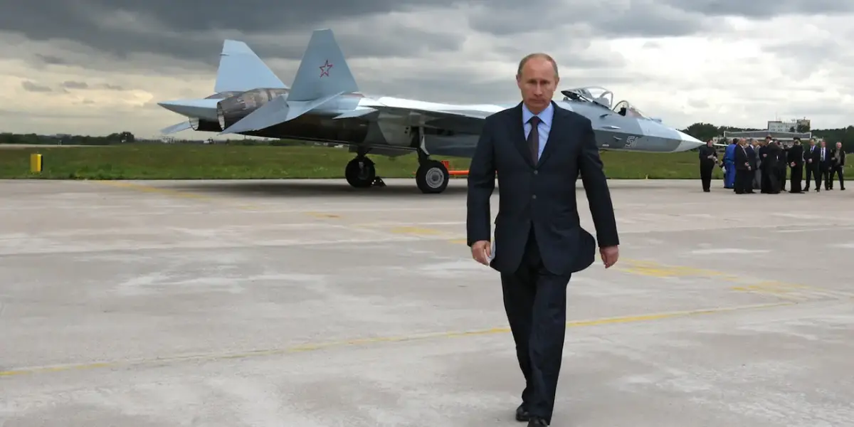 Russian President Vladimir Putin stands in front of a prototype of the Su-57