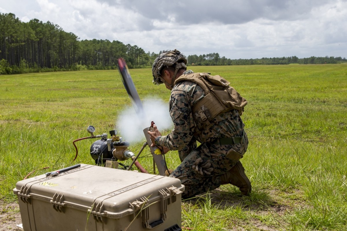 U.S. Marine Corps Lance Cpl. Isiah Enriquez, a native of Lubbock, Texas, and a rifleman with 1st Battalion, 2d Marine Regiment (1/2), 2d Marine Division (2d MARDIV), launches a Switchblade Drone during a training exercise at Camp Lejeune, N.C., July 7, 2021. U.S. Marine Corps photo by Pfc. Sarah Pysher