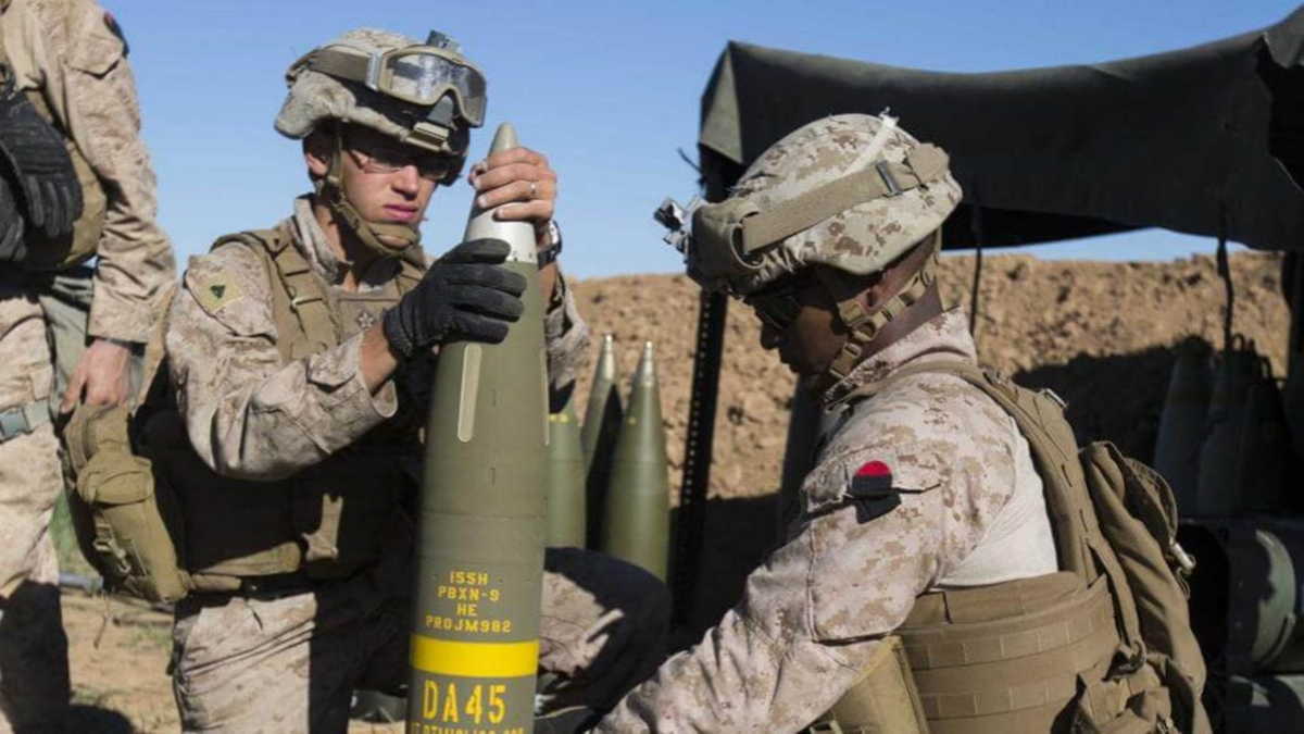 The U.S. Marine Corps prepare an Excalibur 155 mm projectile round on Fire Base Bell, Iraq