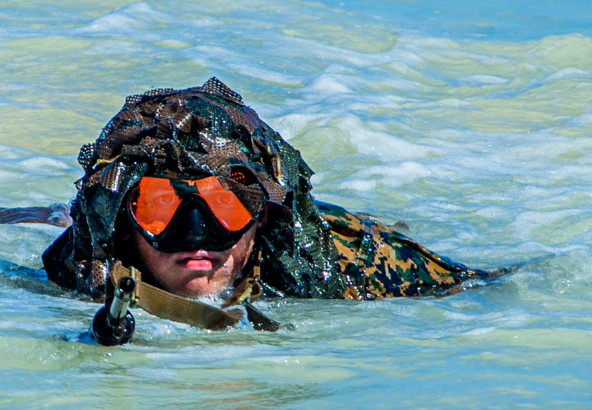 A U.S. Marine with Charlie Company, 1st Battalion, 3d Marines, crawls onto the beach during reconnaissance scout swimmer training part of Exercise Bougainville I at Marine Corps Training Area Bellows, Hawaii, Feb. 8, 2021.US Marine Corps Photo