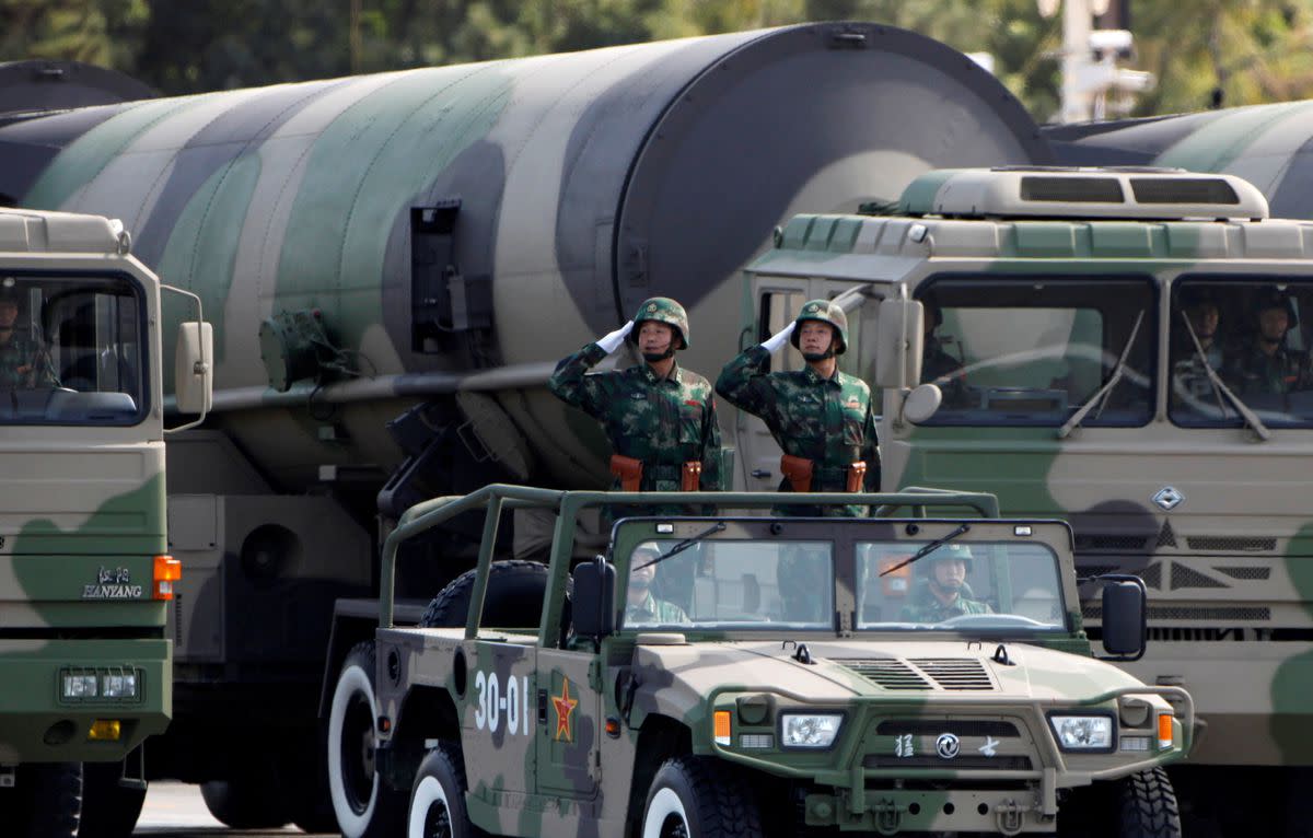 People's Liberation Army (PLA) soldiers salute in front of nuclear-capable missiles during a massive parade to mark the 60th anniversary of the founding of the People's Republic of China in Beijing October 1, 2009. REUTERS/David Gray/File Photo
