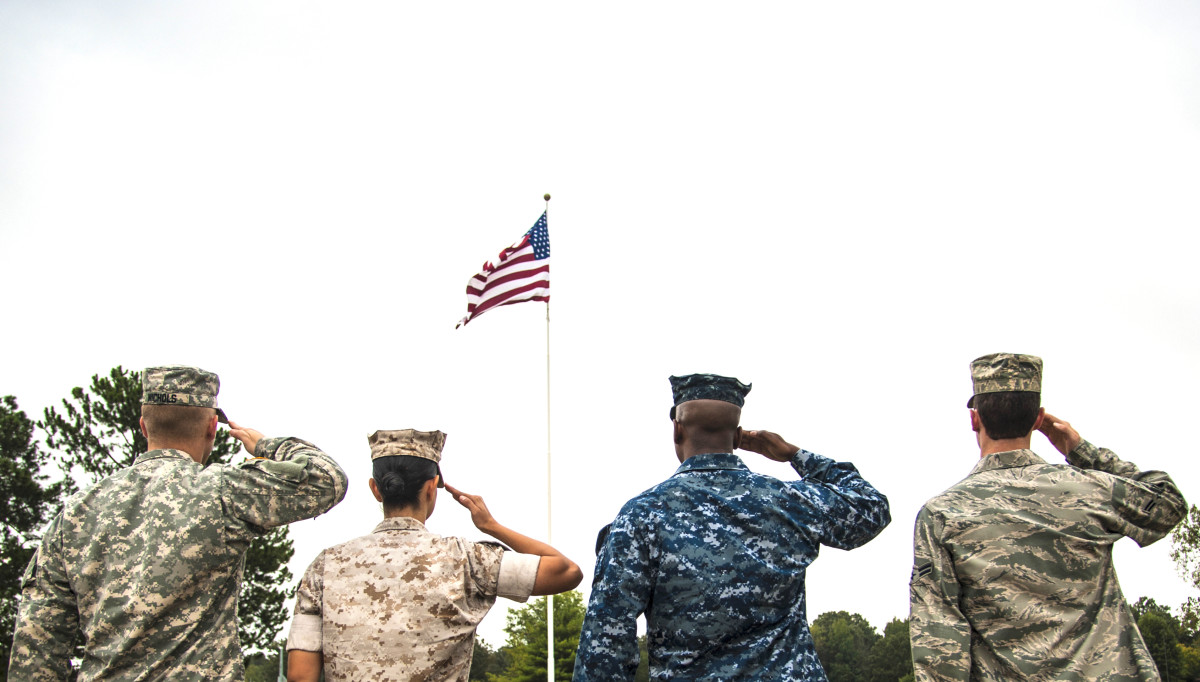 Service members salute the American flag during a retreat ceremony Oct. 2, 2014, at Little Rock Air Force Base, Ark. The four military members represented each branch of the U.S. military and assembled to show solidarity. (U.S. Air Force photo/Airman 1st Class Harry Brexel)